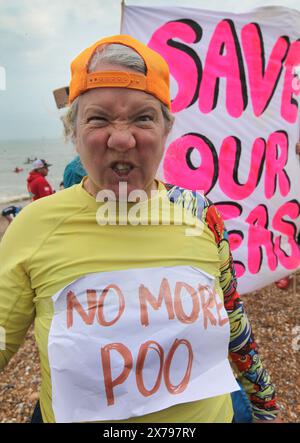 Brighton, England, Großbritannien. Mai 2024. Ein Demonstrant trägt ein Schild mit der Aufschrift „No More Poo“ während der Proteste in der Nähe des West Pier. Surfers Against Sewage (SAS) und ihre Unterstützer gingen ins Meer, um die Menge an Abwasser hervorzuheben, die in Sussex's Wasserstraßen gepumpt wurde. Viele von denen, die in schicken Kleidern zum Thema Abwasser aufs Meer gingen, sagten, sie seien beim Schwimmen bereits krank geworden. (Kreditbild: © Martin Pope/ZUMA Press Wire) NUR REDAKTIONELLE VERWENDUNG! Nicht für kommerzielle ZWECKE! Stockfoto