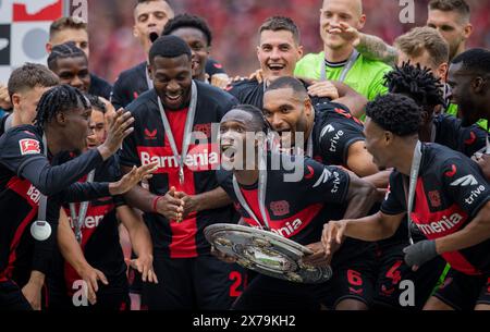 Leverkusen, Deutschland. Mai 2024. Odilon Kossounou (Leverkusen) mit Meisterschale, Jeremie Frimpong (Leverkusen), Timothy Fosu-Mensah (Leverkusen) Stockfoto