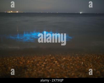 Sheerness, Kent, Großbritannien. Mai 2024. Wetter in Großbritannien: Atemberaubend lebendige, leuchtend blaue Biolumineszenz, die heute Abend am Sheerness Beach in Kent zu sehen ist - die Farbe entsteht, wenn biolumineszierendes Plankton gestört wird. Bilder zeigen Wellen und Steine, die ins Meer geworfen wurden. Quelle: James Bell/Alamy Live News Stockfoto