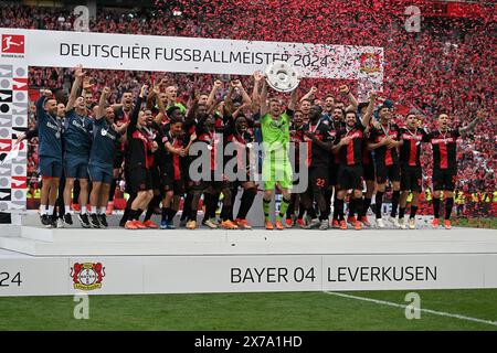 Leverkusen, Deutschland. Mai 2024. Lukas Hradecky (C), Torhüter von Bayer 04 Leverkusen, hält die Trophäe während der Siegerehrung des Titels der Bundesliga in Leverkusen am 18. Mai 2024. Quelle: Ulrich Hufnagel/Xinhua/Alamy Live News Stockfoto