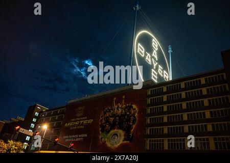 Ein riesiger Banner gratuliert dem Deutschen Meister Bayer 04 Leverkusen, der sogenannten Werkself - das Bayerkreuz mit dem Logo von BAYER auf dem Werksgelände in Leverkusen ist die weltgrößte Leuchtreklame mit 50 Meter Durchmesser und ca. 1700 LED Leuchtmittel. 18.05.2024 Leverkusen Wiesdorf Nordrhein-Westfalen Deutschland *** Ein riesiges Banner gratuliert dem deutschen Champion Bayer 04 Leverkusen, das so genannte Werkself das Bayer-Kreuz mit dem BAYER-Logo auf dem Werksgelände in Leverkusen ist das weltweit größte Leuchtschild mit einem Durchmesser von 50 Metern und ca. 1700 LED-Leuchten 18 05 2 Stockfoto