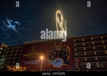 Ein riesiger Banner gratuliert dem Deutschen Meister Bayer 04 Leverkusen, der sogenannten Werkself - das Bayerkreuz mit dem Logo von BAYER auf dem Werksgelände in Leverkusen ist die weltgrößte Leuchtreklame mit 50 Meter Durchmesser und ca. 1700 LED Leuchtmittel. 18.05.2024 Leverkusen Wiesdorf Nordrhein-Westfalen Deutschland *** Ein riesiges Banner gratuliert dem deutschen Champion Bayer 04 Leverkusen, das so genannte Werkself das Bayer-Kreuz mit dem BAYER-Logo auf dem Werksgelände in Leverkusen ist das weltweit größte Leuchtschild mit einem Durchmesser von 50 Metern und ca. 1700 LED-Leuchten 18 05 2 Stockfoto