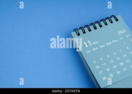 Schreibtischkalender November 2024 auf blauem Hintergrund. Kopierbereich. Stockfoto
