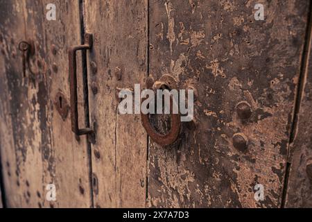 Antike Vintage-Tür mit Schlüsselloch und Ringgriff. Antike Holztür mit geschmiedetem Metallschloss und -Griff. Stockfoto