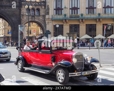 Prag, Tschechische Republik - 10. Mai 2024: Touristen fahren in einem offenen Cabrio, im Stil eines alten Timers, auf dem Platz vor dem Pulverturm entlang Stockfoto