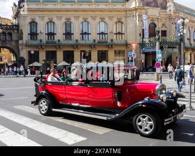 Prag, Tschechische Republik - 10. Mai 2024: Touristen fahren in einem offenen Cabrio, im Stil eines alten Timers, auf dem Platz vor dem Pulverturm entlang Stockfoto