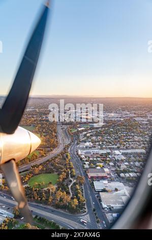 Blick aus einem Flugzeugfenster, das über Adelaide bei Sonnenuntergang fliegt Stockfoto