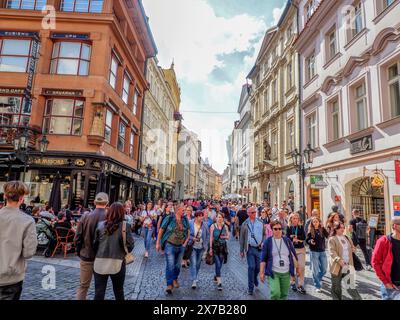 Prag, Tschechische Republik - 10. Mai 2024: Eine geschäftige Menschenmenge füllt eine malerische Straße mit historischen Gebäuden und Cafés in der Altstadt von Pragues. Menschen Stockfoto