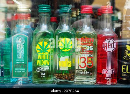 Prag, Tschechische Republik - 10. Mai 2024: Ein Schaufenster zeigt eine Vielzahl von bunten Mini-Spirituosenflaschen, darunter Absinth und Cannabis-Wodka, Stockfoto