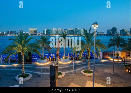 Abu Dhabi, Vereinigte Arabische Emirate - 3. Mai 2024: Dämmerung am Al Raha Beach mit Blick auf die modernen Gebäude vor der Skyline von Abu Dhabi Stockfoto