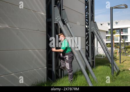 Ein Arbeiter steigt auf das Dach eines Gebäudes, um das Dach zu inspizieren. Stockfoto