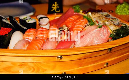 Japanisches Sushi- und Sashimi-Set, serviert auf einem Holzboot Stockfoto