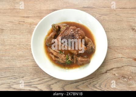 Gedämpftes Hähnchenschenkel und Füße mit Knoblauch-Sauce mit schwarzer Pfeffer auf einem Teller Stockfoto