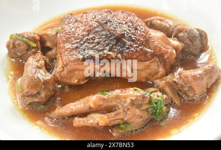 Gedämpftes Hähnchenschenkel und Füße mit Knoblauch-Sauce mit schwarzer Pfeffer auf einem Teller Stockfoto