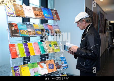 Ein Käuferin liest ein Buch vor Regalen mit Büchern, Buchladen. November 2018. Kiew, Ukraine Stockfoto
