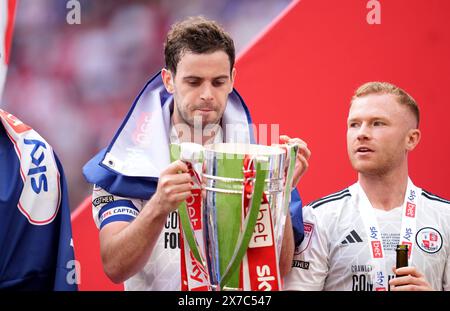 Crawley Town's Dion Conroy feiert auf dem Spielfeld mit der Trophäe nach dem Play-off-Finale der Sky Bet League 2 im Wembley Stadium, London. Bilddatum: Sonntag, 19. Mai 2024. Stockfoto