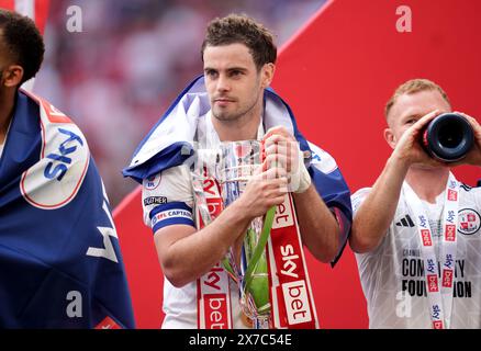 Crawley Town's Dion Conroy feiert auf dem Spielfeld mit der Trophäe nach dem Play-off-Finale der Sky Bet League 2 im Wembley Stadium, London. Bilddatum: Sonntag, 19. Mai 2024. Stockfoto