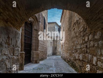 Baeza, Spanien - 5. April 2024: Enge Straße und Steinbogen entlang des Paseo de las Murallas Pfades im historischen Stadtzentrum von Baeza Stockfoto