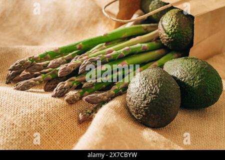Grüner Spargel und frische Avocados aus nächster Nähe auf rustikalem Hintergrund Stockfoto