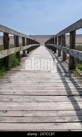 Strandszenen vom Chesil Beach in Dorset mit Blick auf den Strand einschließlich einer Brücke über einen Wassereintritt. Stockfoto