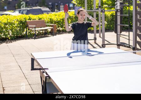 Mädchen spielt im Freien Tischtennis Stockfoto