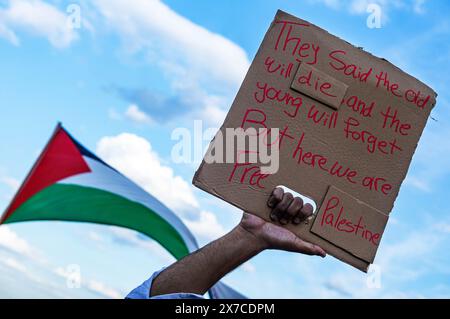 18. Mai 2024, Warschau, Mazowien, Polen: Ein Demonstrant hält während der Demonstration ein Plakat vor einer palästinensischen Flagge. Pro-palästinensische Demonstranten veranstalten eine die-in-Demonstration auf dem Warschauer Schlossplatz. Im Gedenken an die Nakba ab 1948 lagen die Demonstranten bewegungslos auf dem Boden. Danach erzählten einige Palästinenser und Polnisch-Palästinenser ihren Geschichten vor dem versammelten Publikum. (Credit Image: © Neil Milton/SOPA Images via ZUMA Press Wire) NUR REDAKTIONELLE VERWENDUNG! Nicht für kommerzielle ZWECKE! Stockfoto