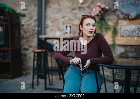 Eine junge Frau genießt ihre Zeit in einem malerischen Café im Freien Stockfoto