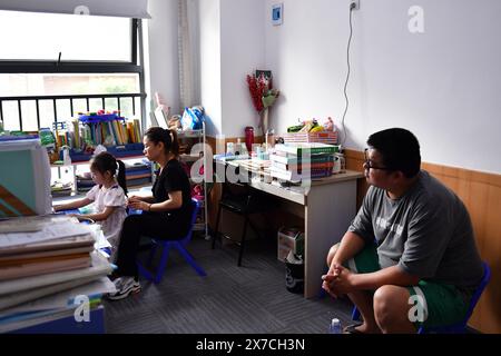 (240519) -- CHANGSHA, 19. Mai 2024 (Xinhua) -- Tochter Zhang Yuhan (L) besucht eine Klasse in Begleitung seines Vaters Zhang Yongsheng in einem Kinderentwicklungszentrum in Changsha, zentralchinesische Provinz Hunan, 17. Mai 2024. Obwohl sie hörgeschädigt waren, gelang es Zhang Yongsheng und seiner Frau Zhan Jingwen, ihre Tochter, die ebenfalls an der gleichen Behinderung leidet, im Alter von zwei Jahren zu hören. Durch einen Imbissstand auf einem Nachtmarkt und dank der Unterstützung ihrer Verwandten und Freunde gelang es dem Paar, sich ein Cochlea-Implantat für das linke Ohr ihrer Tochter und ein Hörgerät für das linke Ohr ihrer Tochter zu leisten Stockfoto