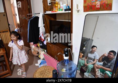 (240519) -- CHANGSHA, 19. Mai 2024 (Xinhua) -- Zhang Yongsheng und seine Familie ruhen sich am 17. Mai 2024 zu Hause in Changsha, der Provinz Hunan in Zentralchina aus. Obwohl sie hörgeschädigt waren, gelang es Zhang Yongsheng und seiner Frau Zhan Jingwen, ihre Tochter, die ebenfalls an der gleichen Behinderung leidet, im Alter von zwei Jahren zu hören. Durch einen Imbissstand auf einem Nachtmarkt und dank der Unterstützung ihrer Verwandten und Freunde gelang es dem Paar, sich ein Cochlea-Implantat für das linke Ohr ihrer Tochter und ein Hörgerät für das rechte Ohr ihrer Tochter zu leisten. „Es ist zu teuer, eine ähnliche Behandlung zu haben Stockfoto