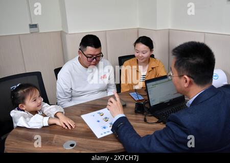 (240519) -- CHANGSHA, 19. Mai 2024 (Xinhua) -- Zhang Yongsheng und seine Familie lassen ihre Cochlea-Implantate in einem Cochlea-Service-Center in der zentralchinesischen Provinz Hunan am 22. April 2024 einschalten und debuggen. Obwohl sie hörgeschädigt waren, gelang es Zhang Yongsheng und seiner Frau Zhan Jingwen, ihre Tochter, die ebenfalls an der gleichen Behinderung leidet, im Alter von zwei Jahren zu hören. Durch einen Imbissstand auf einem Nachtmarkt und dank der Unterstützung ihrer Verwandten und Freunde gelang es dem Paar, sich ein Cochlea-Implantat für das linke Ohr ihrer Tochter und ein Hörgerät für das rechte Ohr ihrer Tochter zu leisten Stockfoto