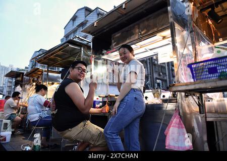 (240519) -- CHANGSHA, 19. Mai 2024 (Xinhua) -- dieses Foto von Tochter Zhang Yuhan mit der Kamera des Reporters zeigt ihre Eltern Zhang Yongsheng und Zhan Jingwen auf dem Nachtmarkt in Sifangping in Changsha, zentralchinesischer Provinz Hunan, 15. Mai 2024. Obwohl sie hörgeschädigt waren, gelang es Zhang Yongsheng und seiner Frau Zhan Jingwen, ihre Tochter, die ebenfalls an der gleichen Behinderung leidet, im Alter von zwei Jahren zu hören. Durch einen Imbissstand auf einem Nachtmarkt und dank der Unterstützung ihrer Verwandten und Freunde gelang es dem Paar, sich ein Cochlea-Implantat für das linke Ohr ihrer Tochter und ein zu leisten Stockfoto