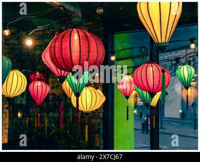 Farbenfrohe Windlichter im chinesischen Stil hängen in einem Restaurant und blicken durch das Glasfenster und auf die andere Seite Stockfoto