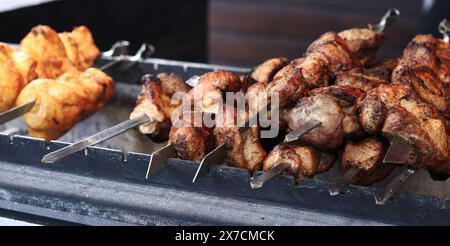 Kebabs auf Spießen, Nahaufnahme. Food Court auf der Messe, Outdoor Cooking. Warmes und leckeres Essen. Koche Schaschlik auf Kohlen. Gegrillter Kebab, gekocht auf einem Meta Stockfoto