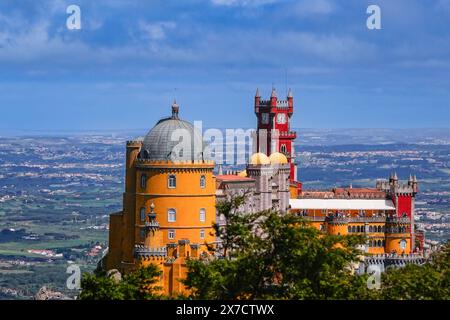 Der Pena-Palast oder das historische Schloss Palácio da Pena vom Hochkreuz in Sintra, Portugal. Der märchenhafte Schlosspalast gilt als eines der schönsten Beispiele der portugiesischen Romantik des 19. Jahrhunderts der Welt. Stockfoto