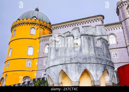 Die vielseitigen Stile des Pena-Palastes oder des historischen Schlosses Palácio da Pena von der Bushaltestelle in Sintra, Portugal. Der märchenhafte Schlosspalast gilt als eines der schönsten Beispiele der portugiesischen Romantik des 19. Jahrhunderts der Welt. Stockfoto