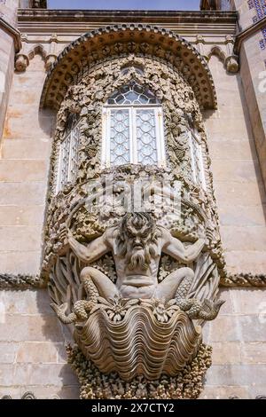 Der kunstvoll geschnitzte Triton Portico aus Stein an der Hauptfassade des Pena Palace oder des historischen Schlosses Palácio da Pena in Sintra, Portugal. Der märchenhafte Schlosspalast gilt als eines der schönsten Beispiele der portugiesischen Romantik des 19. Jahrhunderts der Welt. Stockfoto