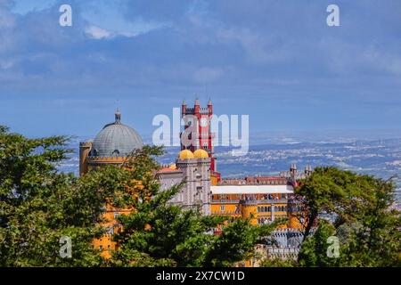 Der Pena-Palast oder das historische Schloss Palácio da Pena vom Hochkreuz in Sintra, Portugal. Der märchenhafte Schlosspalast gilt als eines der schönsten Beispiele der portugiesischen Romantik des 19. Jahrhunderts der Welt. Stockfoto