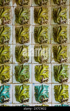 Geometrisch-maurische Fliesen, bekannt als Azulejos, schmücken die Fassade innerhalb des Tritonbogens, der zum Innenhof der Bögen des Pena-Palastes oder zum historischen Schloss Palácio da Pena in Sintra, Portugal führt. Der märchenhafte Schlosspalast gilt als eines der schönsten Beispiele der portugiesischen Romantik des 19. Jahrhunderts der Welt. Stockfoto