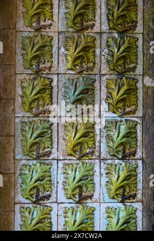 Geometrisch-maurische Fliesen, bekannt als Azulejos, schmücken die Fassade innerhalb des Tritonbogens, der zum Innenhof der Bögen des Pena-Palastes oder zum historischen Schloss Palácio da Pena in Sintra, Portugal führt. Der märchenhafte Schlosspalast gilt als eines der schönsten Beispiele der portugiesischen Romantik des 19. Jahrhunderts der Welt. Stockfoto