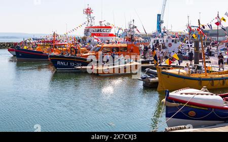 Poole, Dorset, Großbritannien. Mai 2024. Tausende strömen an einem warmen, sonnigen Nachmittag zum Poole Lifeboat Festival, während das RNLI dieses Jahr sein 200-jähriges Bestehen feiert. Die Parade der Segel umfasst viele historische RNLI Rettungsboote, die aktuelle RNLI Flotte und Besuchspionaden aus anderen Ländern, einschließlich Ruderboote. Quelle: Carolyn Jenkins/Alamy Live News Stockfoto