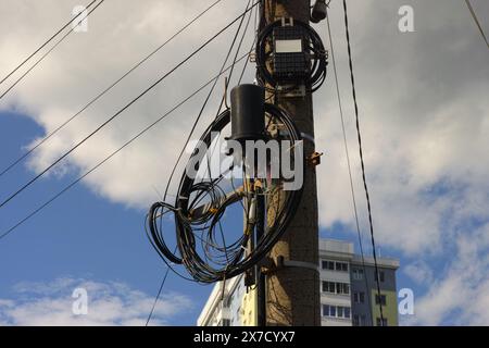 Optische Kabel, die an einem Strommast hängen. Stockfoto