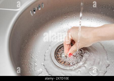 Hausfrau schließt das Abflussloch im Waschbecken Stockfoto