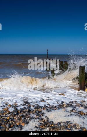 Wellen schlagen gegen eine hölzerne Groyne in Trimingham, North Norfolk, UK in Portrait Stockfoto