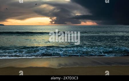 Ein Sturm vertreibt den Sonnenuntergang am Strand von Nazare, Portugal Stockfoto