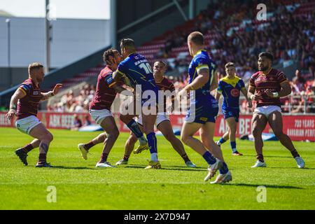 St Helens, Merseyside, Großbritannien. Mai 2024. Betfred Challenge Cup Rugby: Huddersfield Giants vs Warrington Wolves im Totally Wicked Stadium. PAUL VAUGHAN führt den Ball an und wird von der Huddersfield-Verteidigung von LEROY CUDJOE & TUIMOALA LOLOLOHEA angegriffen. Credit James Giblin Photography/Alamy Live News. Stockfoto