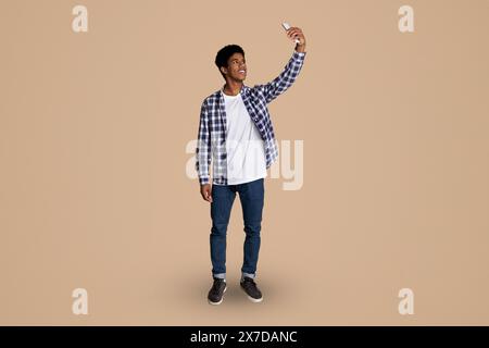 In voller Länge Porträt der Kerl unter selfie auf Telefon Stockfoto