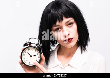 Eine Geschäftsfrau, die einen Wecker hält Stockfoto