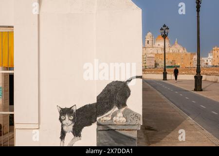 Ein Wandbild einer Katze, gemalt in einem Kindergarten entlang der Vendaval-Küstenpromenade in Cadiz, Spanien. Die Uferpromenade ist bekannt für eine Kolonie wilder Katzen, die entlang der Meeresmauer leben. Stockfoto