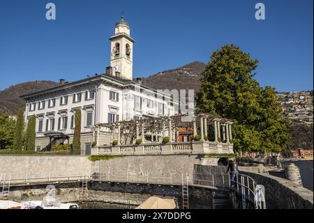 Wunderschöner kleiner Hafen in Cernobbio mit einer Kirche im Hintergrund Stockfoto