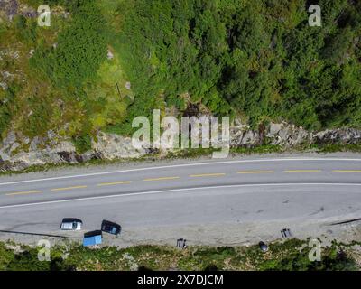 Drohnenfoto. Blick von oben auf einen norwegischen Berg mit einer Autobahn entlang mit einem Rastbereich mit Holztischen und -Bänken. Stockfoto